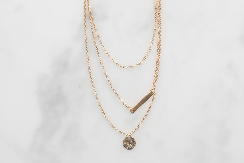 Dainty gold necklace on neutral background